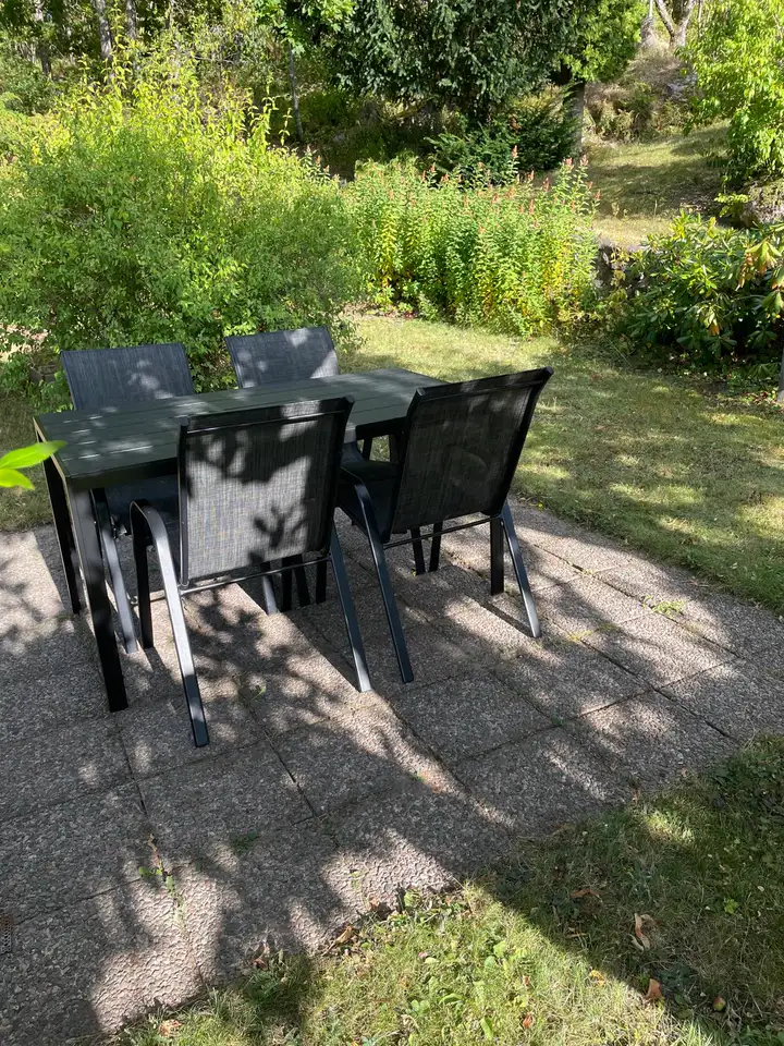 Terrasse im Garten mit Esstisch und vier Stühlen